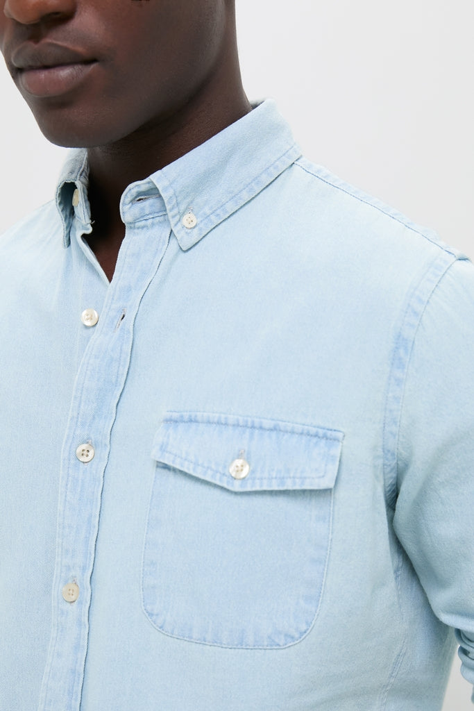Light Blue Washed Denim Shirt with a classic button-down design, featuring a chest flap pocket. Effortlessly high-end and fun, perfect for versatile, year-round wear.