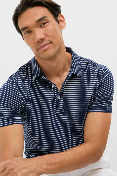 Young man in a classic navy striped polo, embodying effortless style and fun. Perfect for versatile, high-end occasions from golf to happy hour.