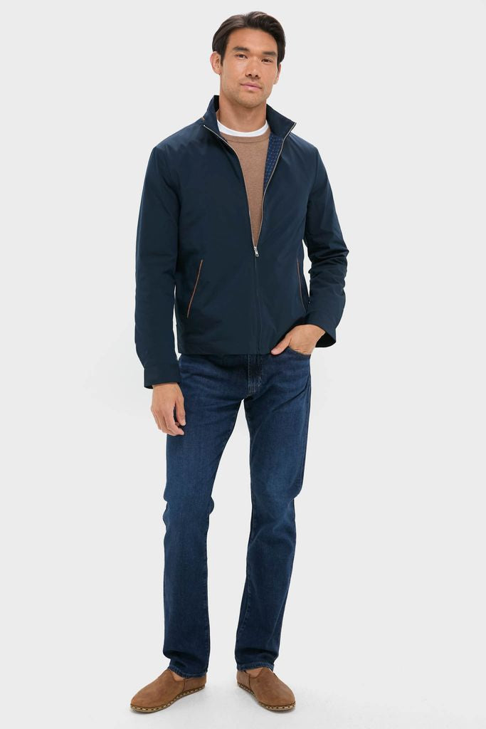 Man in Navy Blue Stanley Jacket and jeans, embodying a classic, effortless style. The jacket features suede-trimmed pockets and a vintage pattern lining, exuding high-end comfort.