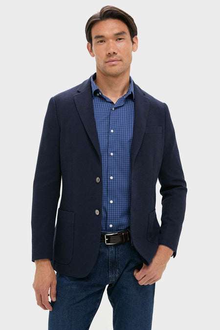 Navy Blue Knit Travel Blazer on mannequin, styled with a blue gingham shirt and jeans. Classic, effortless design perfect for high-end, fun travel or business occasions.
