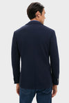 Back view of a person wearing the Navy Blue Knit Travel Blazer, showcasing its classic, effortless design perfect for high-end travel or business, paired with jeans.