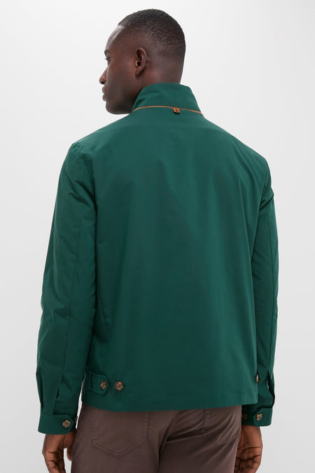 Man wearing the classic Dark Green Stanley Jacket, featuring buttoned tabs, suede-trimmed pockets, and a matte finish, paired with brown trousers for an effortless, high-end look.
