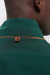 Close-up of a dark-skinned person wearing the classic Dark Green Stanley Jacket, featuring a suede-trimmed collar for an effortless, high-end look.