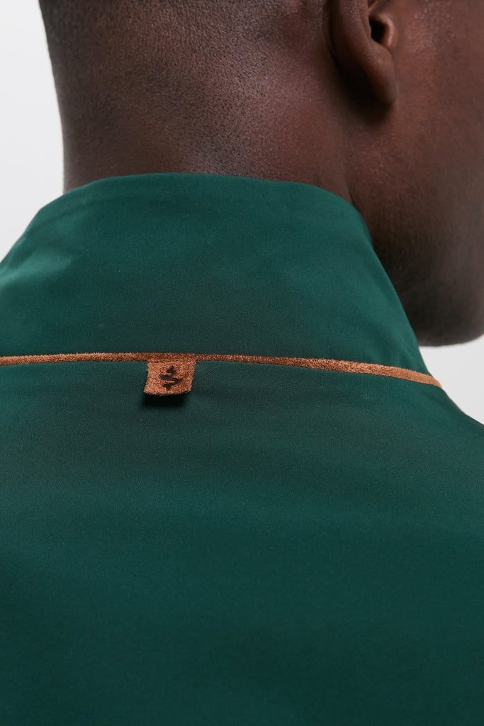 Close-up of a dark-skinned person wearing the classic Dark Green Stanley Jacket, featuring a suede-trimmed collar for an effortless, high-end look.