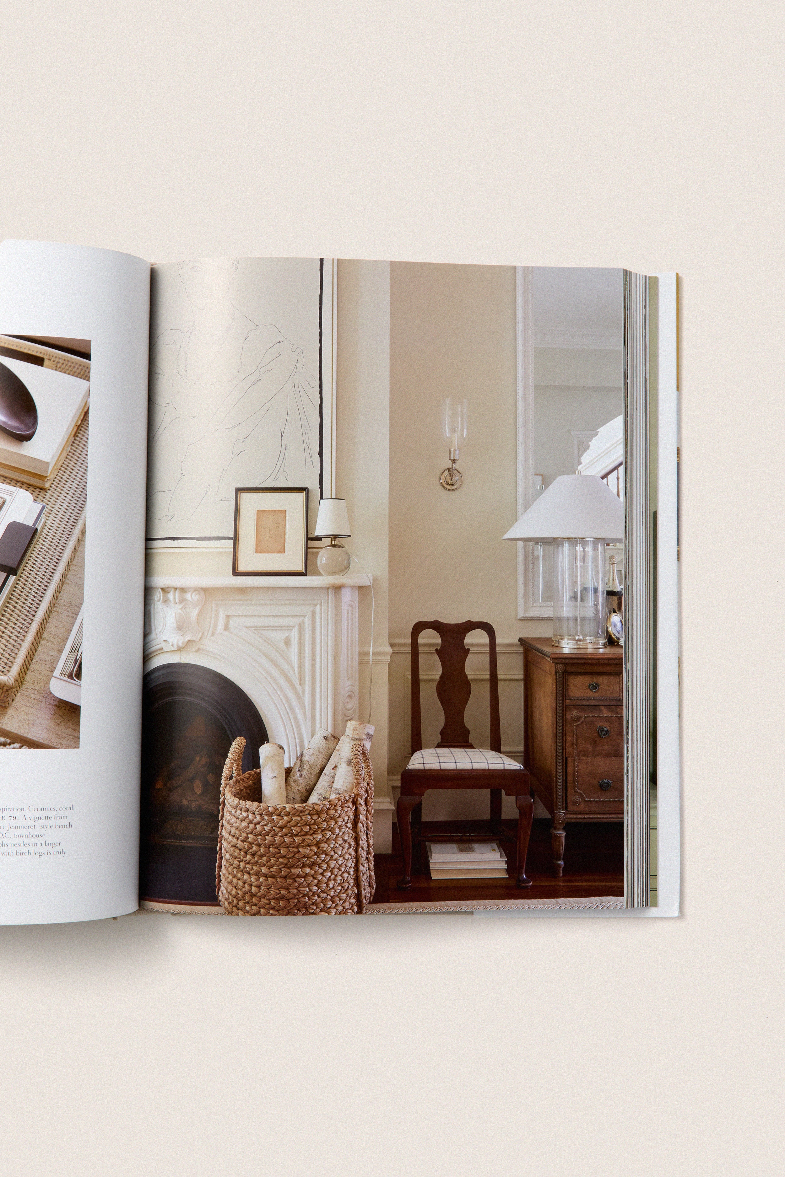 Artful Home open book showcases classic, effortless home decor with a marble mantel, wicker basket, and vintage furniture, embodying high-end design principles like palette and texture.