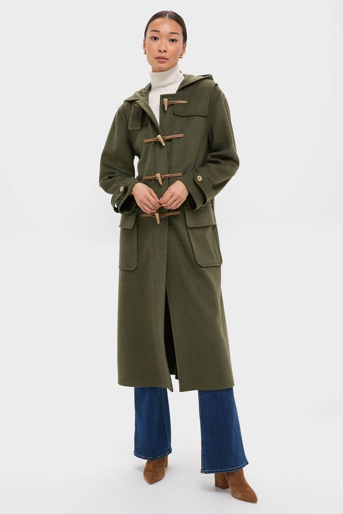 Woman models the classic, high-end Olive Green Arthur Toggle Stadium Coat with wooden-toggle fastenings, exuding effortless style, perfect for fun, cool-weather activities.