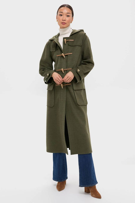 Woman models the classic, high-end Olive Green Arthur Toggle Stadium Coat with wooden-toggle fastenings, exuding effortless style, perfect for fun, cool-weather activities.