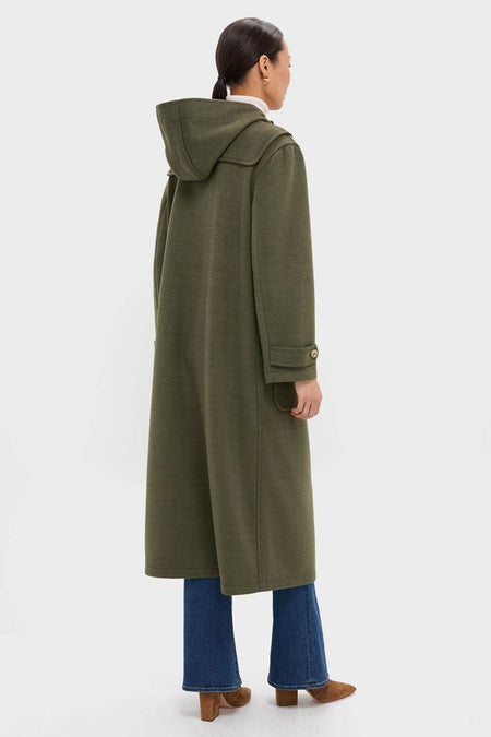 Person wearing the classic Olive Green Arthur Toggle Stadium Coat, featuring a hood and horn toggles, paired effortlessly with jeans and suede ankle boots for a high-end, fun look.