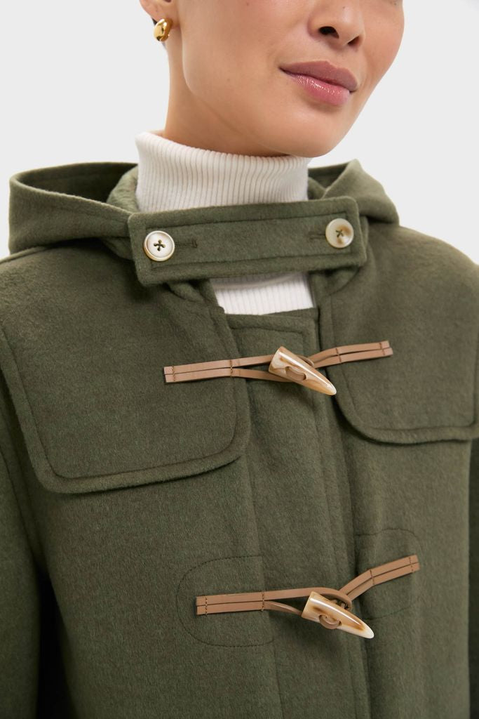 Olive Green Arthur Toggle Stadium Coat with hood, horn toggles, over white turtleneck; classic, effortless high-end style for cozy, fun winter activities.