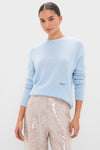 Model in the classic Ice Blue Cashmere Bodie Boyfriend Crewneck, paired with high-waisted sequined pants, showcasing an effortless and high-end look.