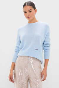 Model in the classic Ice Blue Cashmere Bodie Boyfriend Crewneck, paired with high-waisted sequined pants, showcasing an effortless and high-end look.