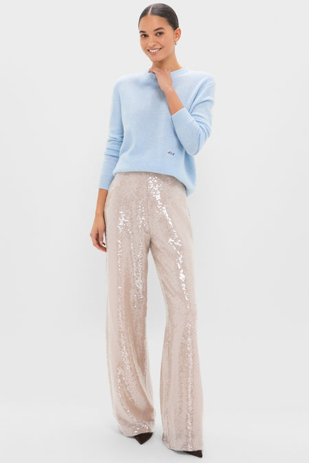 Young woman models the Ice Blue Cashmere Bodie Boyfriend Crewneck, showcasing its classic, effortless style paired with high-end, fun sequined trousers.
