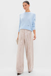 Woman models Ice Blue Cashmere Bodie Boyfriend Crewneck, a classic, effortless sweater with relaxed fit, paired with high-end, sequin trousers and a chic evening clutch.