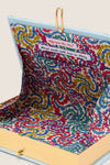 Portofino Book Clutch with a pale blue exterior, gold-tone clasp, and unique Liberty-style floral lining, exuding classic, effortless style and high-end craftsmanship.
