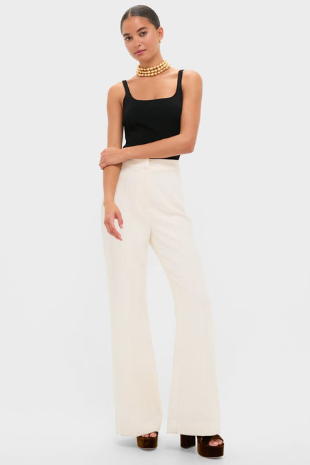 Young woman models Pearl White Crepe Versailles Pant, showcasing their classic, high-rise, wide-leg design, paired effortlessly with a black tank top and gold-tone necklace.