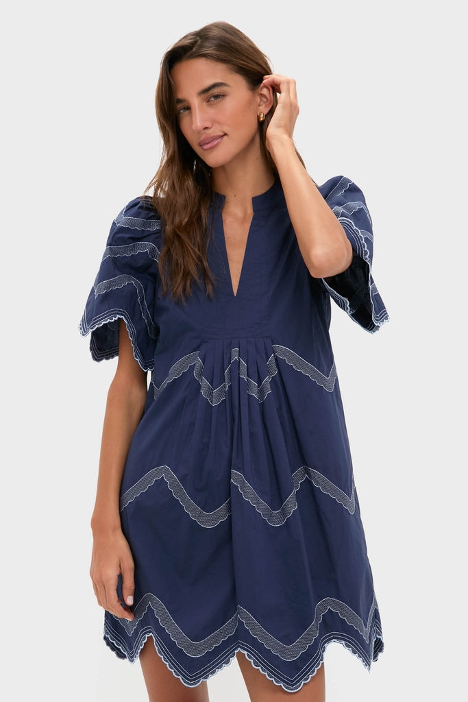 Model in Navy Embroidered Weston Mini Dress with split V-neck, flutter sleeves, and zigzag embroidery, exuding classic, effortless, and high-end style, perfect for fun occasions.