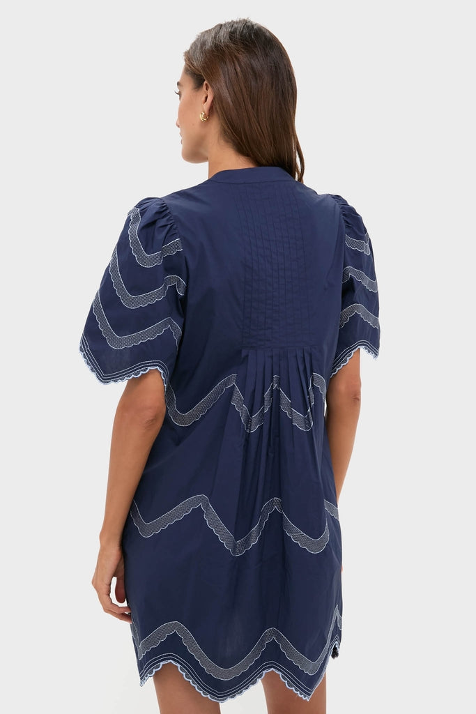 Navy Embroidered Weston Mini Dress with classic puffed sleeves, scalloped hem, and intricate detailing, embodying an effortless, fun, and high-end appeal. Perfect for versatile styling.