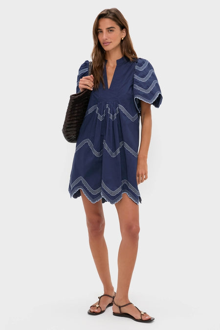 Navy Embroidered Weston Mini Dress: A classic, effortless style featuring puffed sleeves, scalloped embroidery, and pleats, perfect for fun, high-end, warm-weather occasions.
