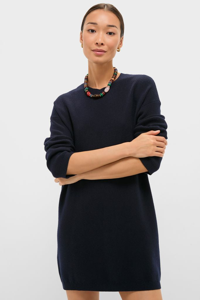 Young woman in a classic Navy Vivianne Crewneck Dress, effortlessly styled with a chunky beaded necklace and gold hoops, exuding fun and high-end elegance.