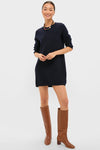 Woman in a classic Navy Vivianne Crewneck Dress with knee-high brown boots, effortlessly styled with a multicolored necklace and hoop earrings, embodying high-end, fun fashion.