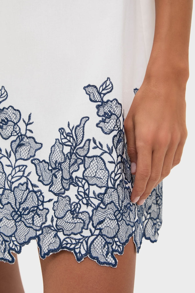 White & Navy Embroidery Mimi Mini Dress with classic navy floral lace hem, showcasing effortless style and high-end design through intricate, fun embroidery and playful detailing.
