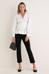 White Tie Front Bow Bea Blouse, a classic and effortless wrap-style with self-tie bow, worn with black trousers and handbag, exuding fun, high-end style.