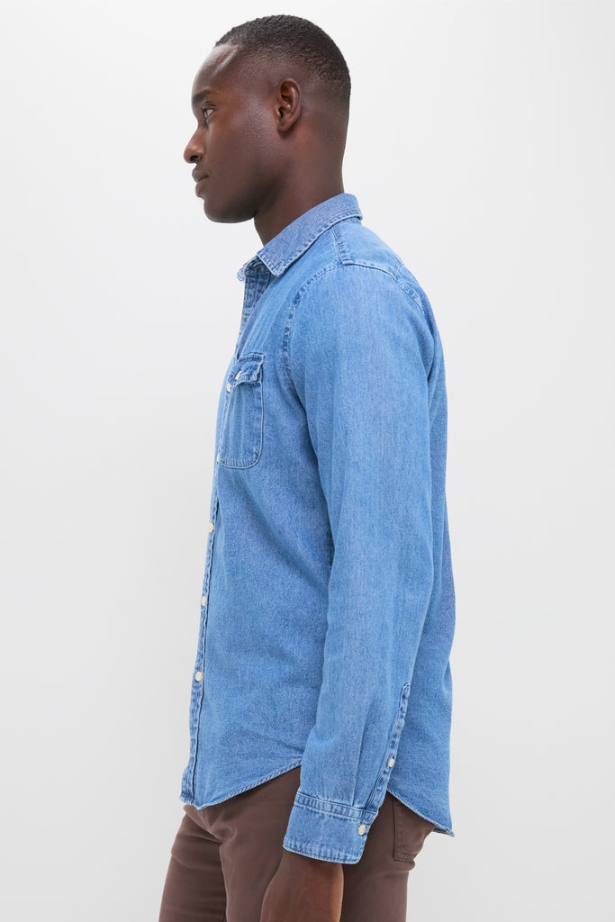 Young Black man models the classic Dark Indigo Washed Denim Shirt, showcasing its effortless, high-end design perfect for year-round, versatile style.