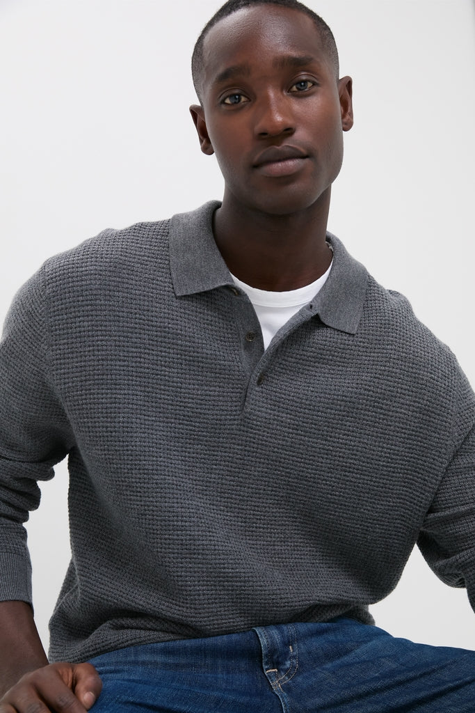 Young man in a Charcoal Merino Waffle Polo, effortlessly styled with jeans. A classic, high-end piece that embodies fun and relaxed sophistication.