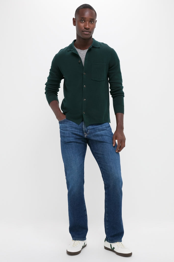 Man models the Forest Green Merino Cardigan, a classic, effortless button-down sweater featuring a waffle weave, designed for high-end comfort and versatile, fun styling.