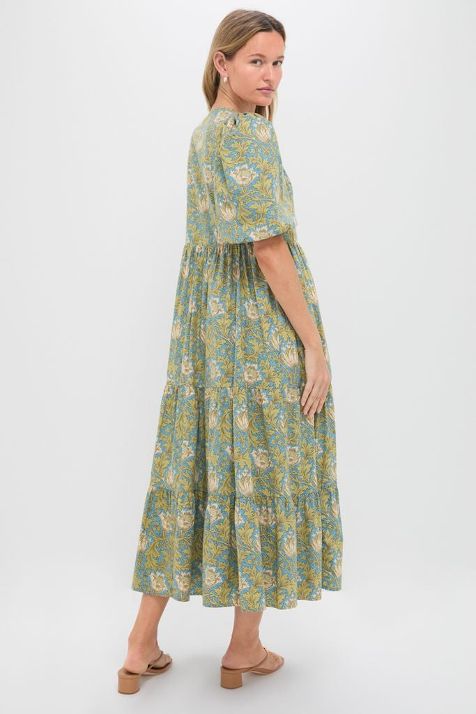 Woman models the Blue & Green Leafy Floral Cisco Maxi Dress, showcasing its classic, effortless, and fun design with puff sleeves and a flowy, high-end silhouette.