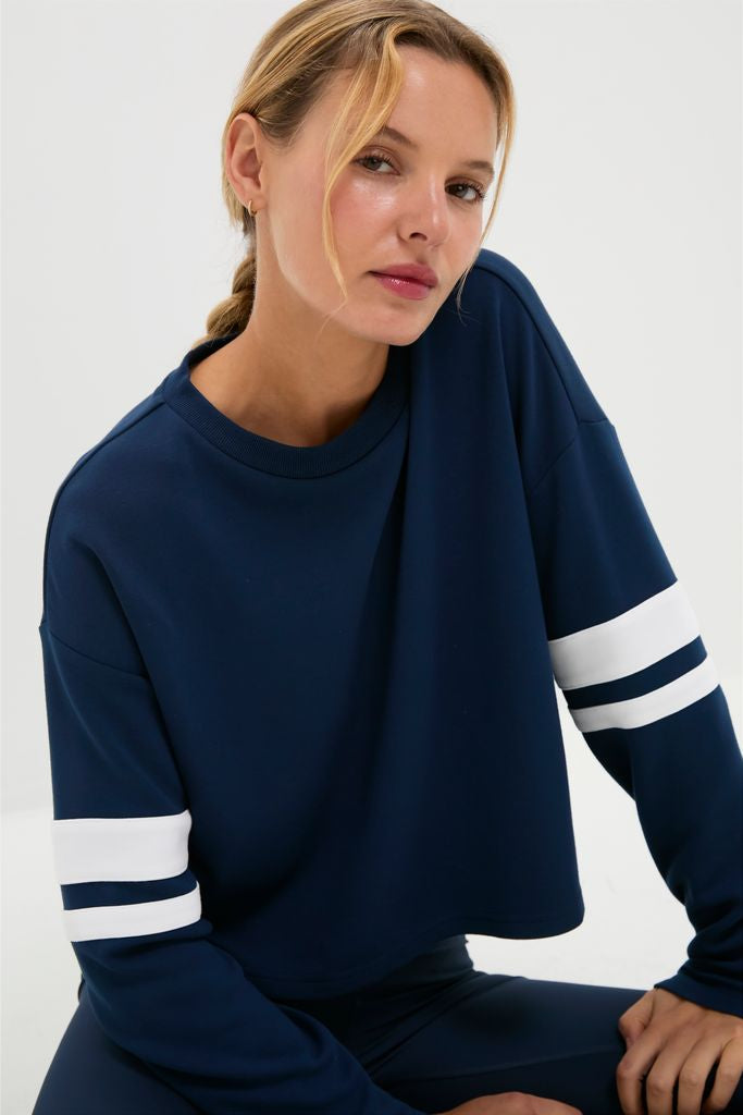 Young woman models the classic Navy Varsity Comfort Stretch Matilda Pullover, showcasing its effortless, fun style with drop shoulders and a relaxed, high-end fit.