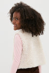 Young girl in a cream Teddy Vest, exuding effortless style with a fun, classic sherpa texture and single button closure, embodying high-end fashion for kids.