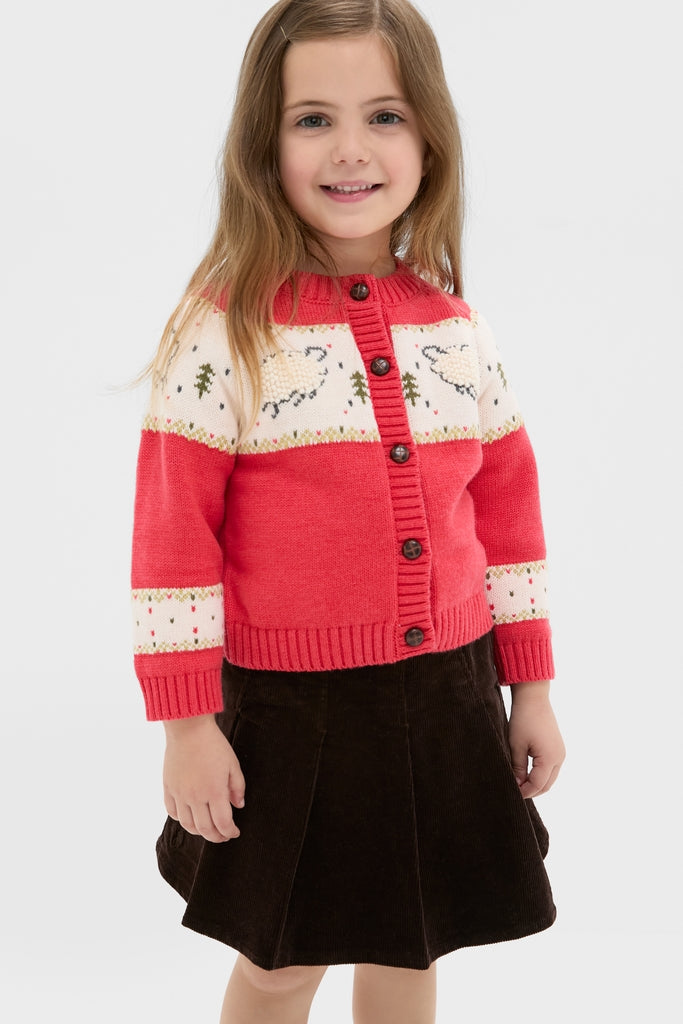 Young girl wears the Red Lamb Sweater, featuring classic sheep patterns and an effortless button front, paired with a fun corduroy skirt for a high-end look.