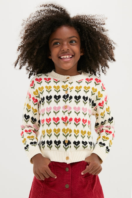 Young girl joyfully models the classic Multi Floral Sweater, featuring tulip motifs. This high-end, effortless cardigan embodies fun and style, perfect for little explorers.
