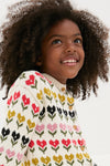 Child smiling in a classic, high-end Multi Floral Sweater, showcasing effortless style with fun tulip motifs and wooden buttons, perfect for little explorers.