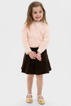 Young girl wearing a classic Light Pink Heart Sweater with ribbed knit finishes, paired effortlessly with a dark brown A-line skirt and gold Mary Jane shoes, exuding fun, high-end style.