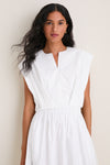 Young woman models the White Wrenli Shortsleeve Pleated Top, showcasing its classic, effortless elegance with a split v-neck, cap sleeves, and pleated hem for high-end style.