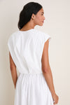 Woman in profile wearing the White Wrenli Shortsleeve Pleated Top with cap sleeves and pleated hem, embodying a classic, effortless, high-end style.