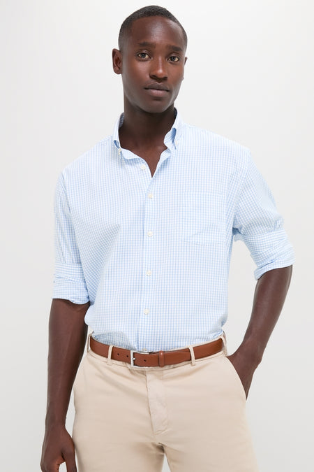 Man wearing Cottage Blue Hanford Performance Twill Sport Shirt with rolled sleeves, beige trousers, and brown belt, embodies classic, effortless style and high-end craftsmanship.