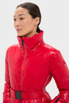 Woman wearing Red Candice Ski Parka; a classic, high-end, glossy puffer with a stand-up collar, front zipper, and effortless belt for a fun, stylish look.