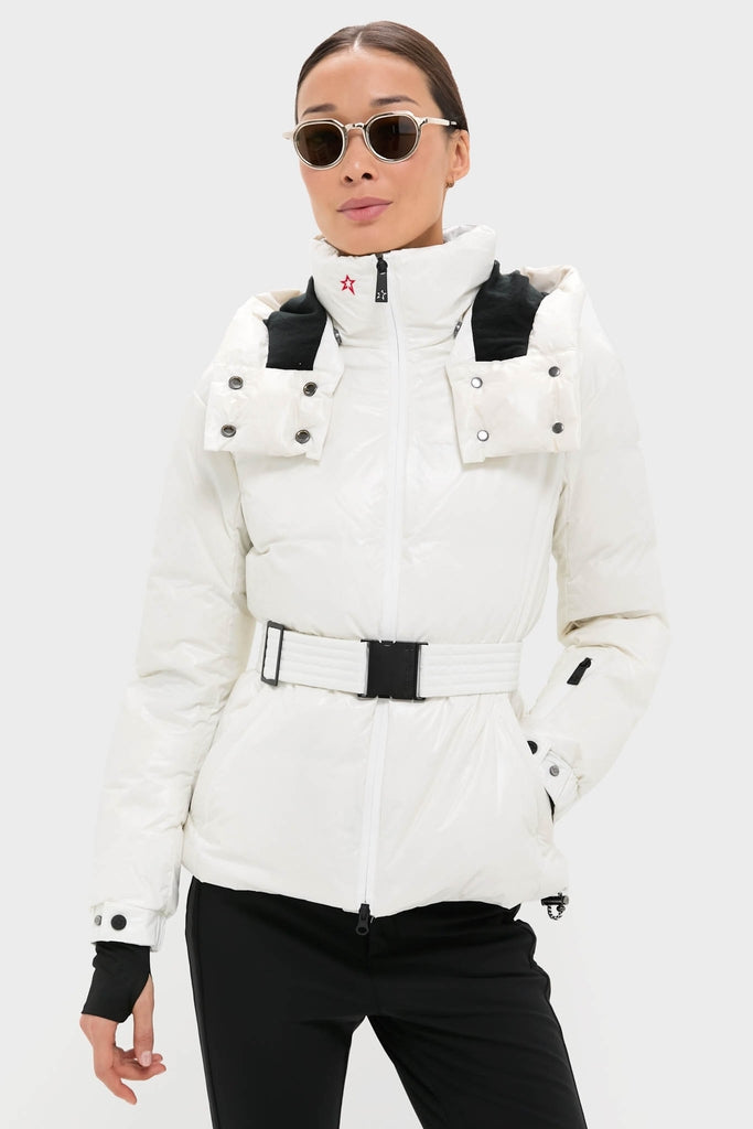 Woman models the Snow White Candice Ski Parka, a classic, high-end puffer with a glossy finish, belted waist, fully zipped, and effortlessly chic for fun, stylish slopes.