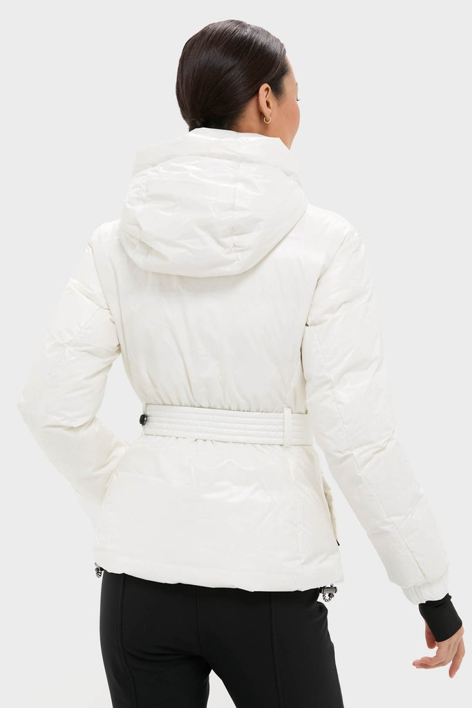 Person in a classic, glossy white Snow White Candice Ski Parka with a cinched waist, effortlessly blending high-end style and performance, perfect for fun on the slopes.