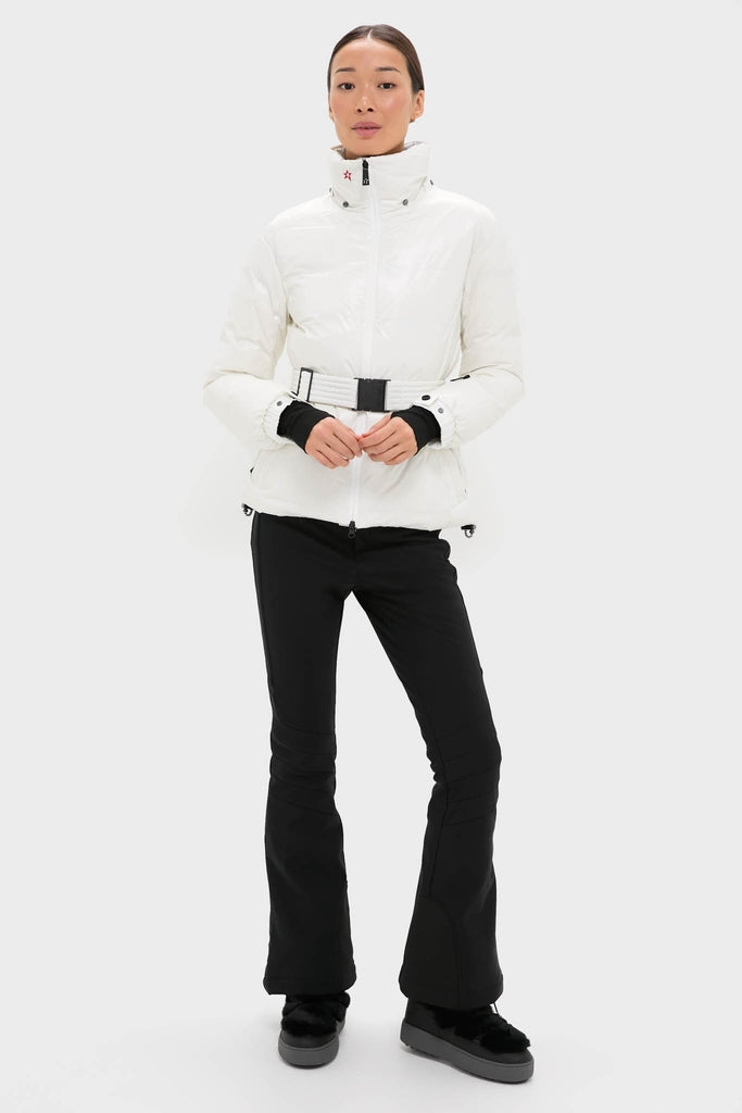 Woman models the Snow White Candice Ski Parka, a classic, high-end puffer with a sleek, belted silhouette, paired with black ski pants and platform winter boots.
