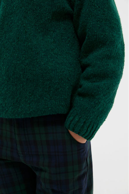 Forest Green Bromo Merino Boy Jumper: A classic, effortless piece for kids, combining fun plaid trousers with a high-end knit sweater featuring shoulder buttons for a preppy vibe.