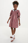 Young girl in a classic, high-end Burgundy Floral Stripe Festa Dress with effortless charm, featuring puffed sleeves, ruffled collar, and fun, swishy skirt.