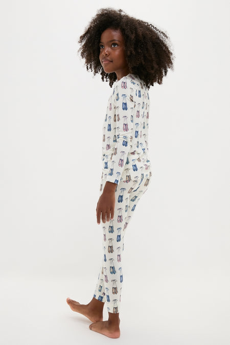 Young girl in profile wearing the Ballet Slippers Kids Bamboo Pj Set, effortlessly stylish with classic off-white, shoe-printed design, showcasing high-end comfort and fun for all seasons.