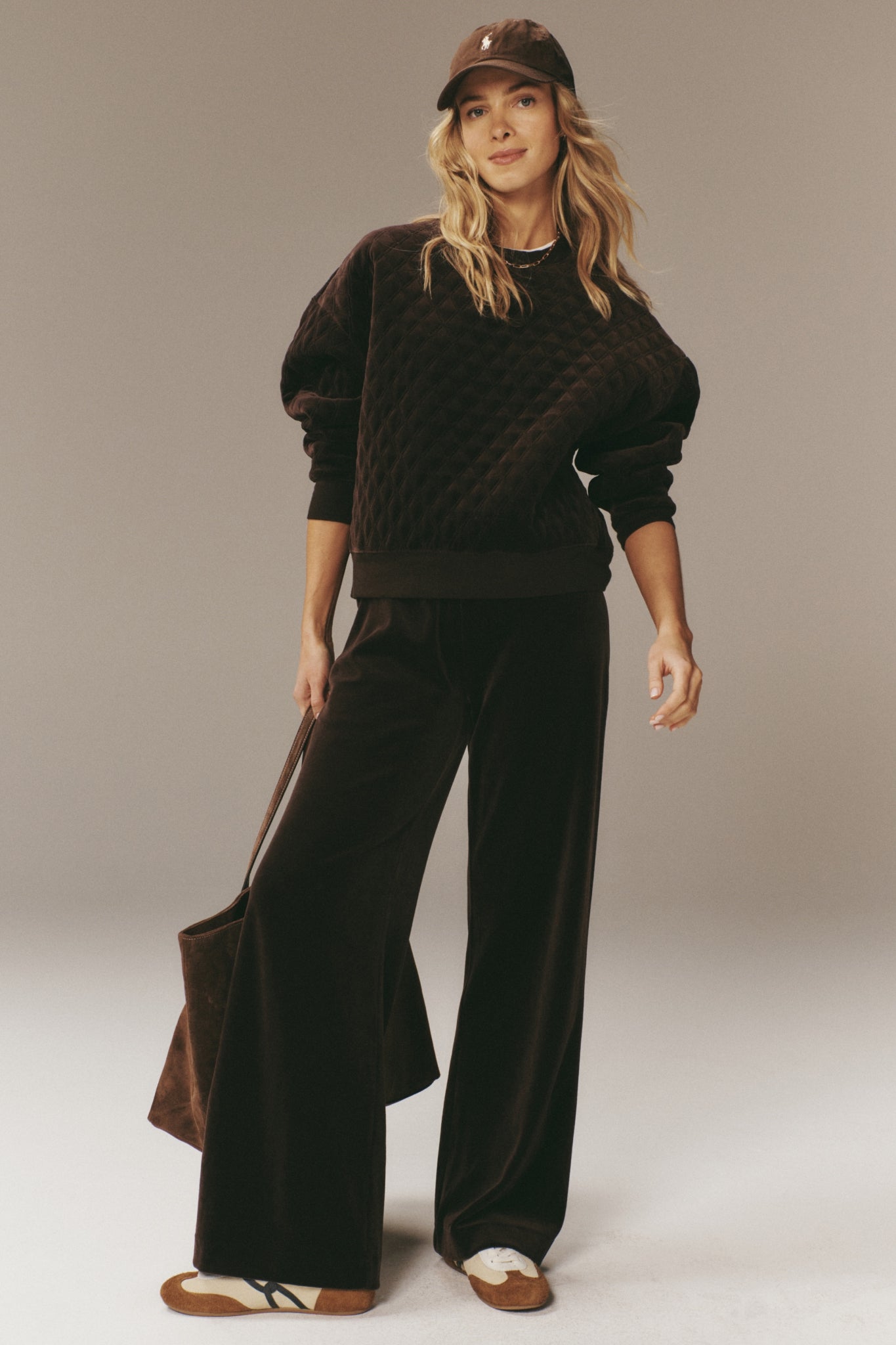 Woman models classic Chocolate Brown Velour Jane Pant, showcasing an effortless, high-end relaxed fit with a wide-leg silhouette and elasticated waistband, epitomizing fun, easy style.