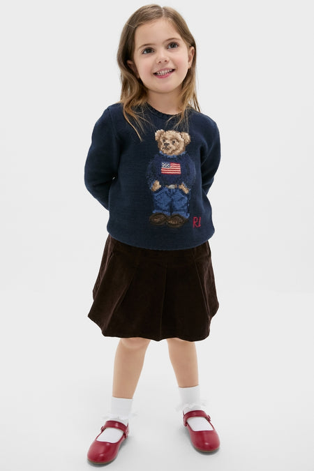 Young girl wearing the Boys Long-Sleeve Flag Bear Crewneck Sweater, showcasing a classic, fun, and high-end style with an iconic Polo Bear design, embodying effortless confidence.
