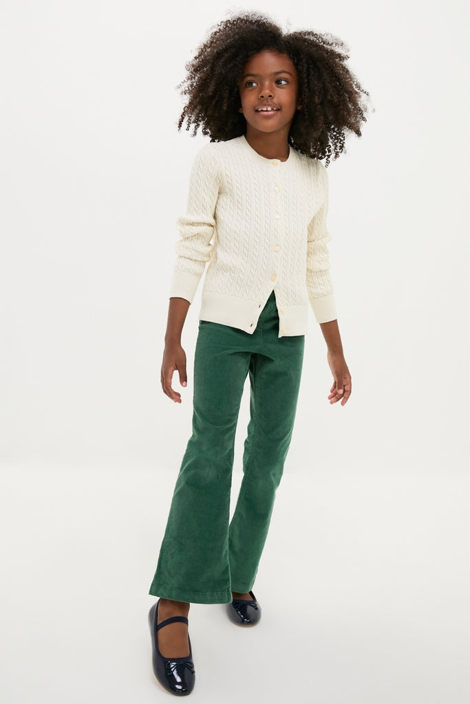 Young girl in a classic, high-end Girls Long-Sleeve Cotton Cable Knit Lurex Cardigan with front button placket, exuding effortless style and fun elegance.