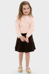 Young girl wearing the Girls Pleated Corduroy Skirt, styled with a classic, effortless look. The skirt, perfect for special occasions, embodies high-end, fun fashion.